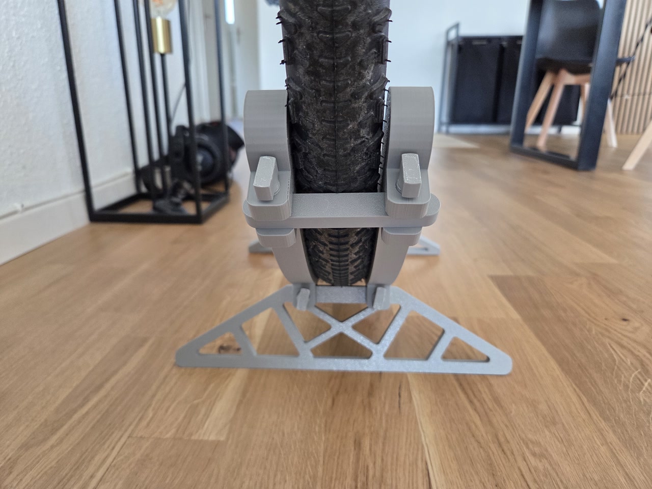 Vista frontale del supporto da pavimento per bicicletta stampato in 3D con ruota inserita