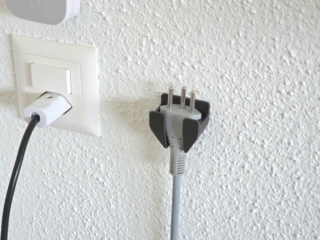 Spina elettrica appoggiata su supporto da parete