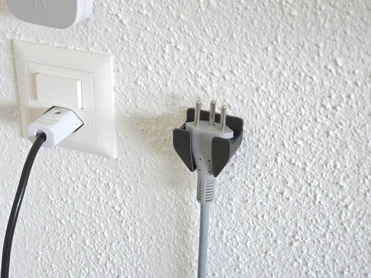 Spina elettrica appoggiata su supporto da parete