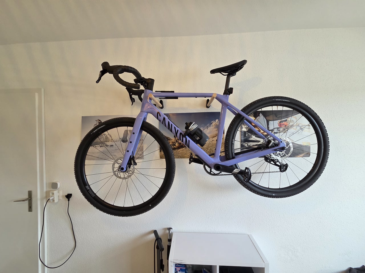 Bicicletta appesa al supporto da parete minimal con due pali in legno Ø25 mm