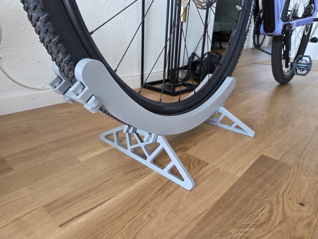 Dettaglio laterale del supporto da pavimento per bicicletta stampato in 3D con ruota appoggiata