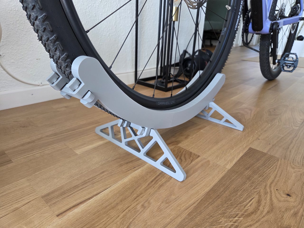 Dettaglio laterale del supporto da pavimento per bicicletta stampato in 3D con ruota appoggiata